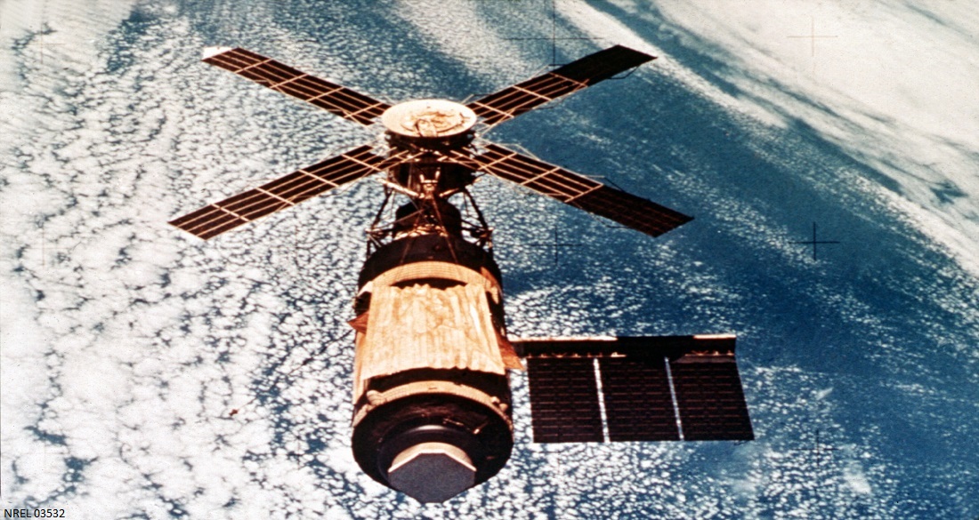 A communications satellite orbits the Earth using the power provided by the solar panels mounted to the top and sides.